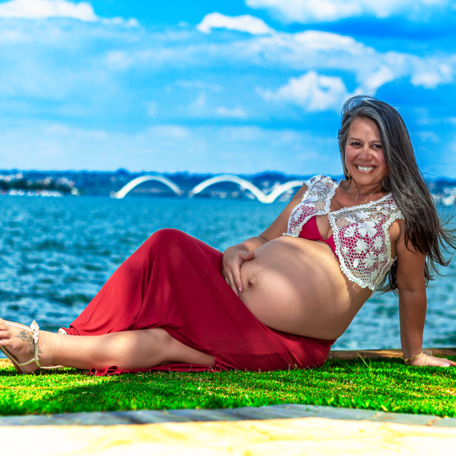 Ana Paula, sentada, à beira do lago no Pontão